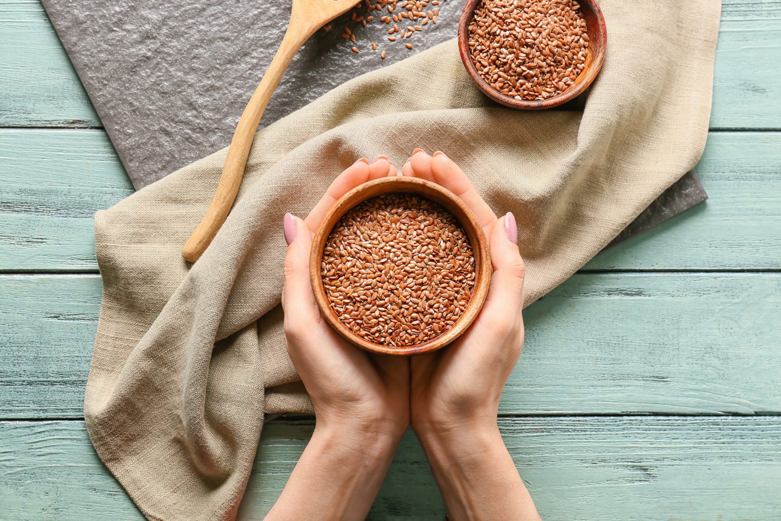 Woman,With,Bowl,Of,Flax,Seeds,At,Table